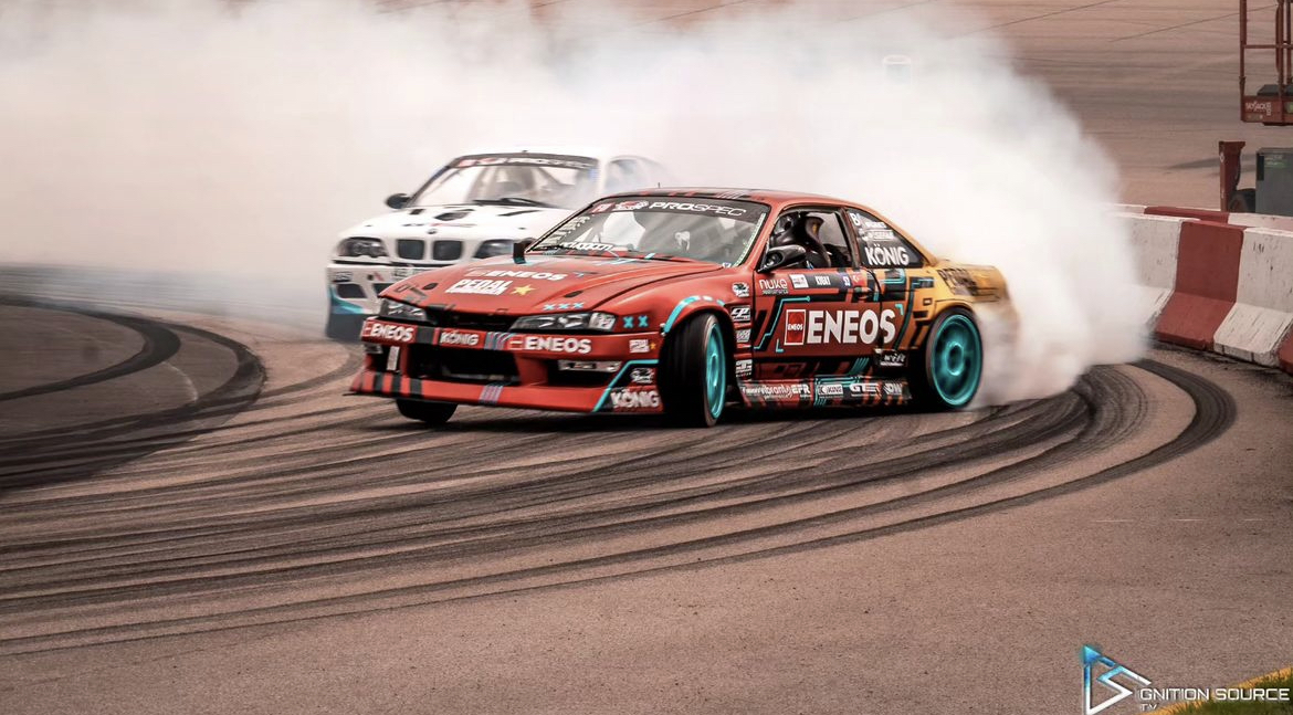 Faruk Kugay in his Nissan s14, leading a formula drift battle against Connor O'Sully in his BMW e46 racer