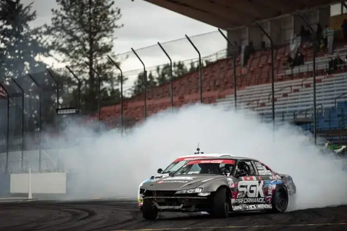 Faruk Kugay drifting his Nissan s14, creating a wall of tire smoke